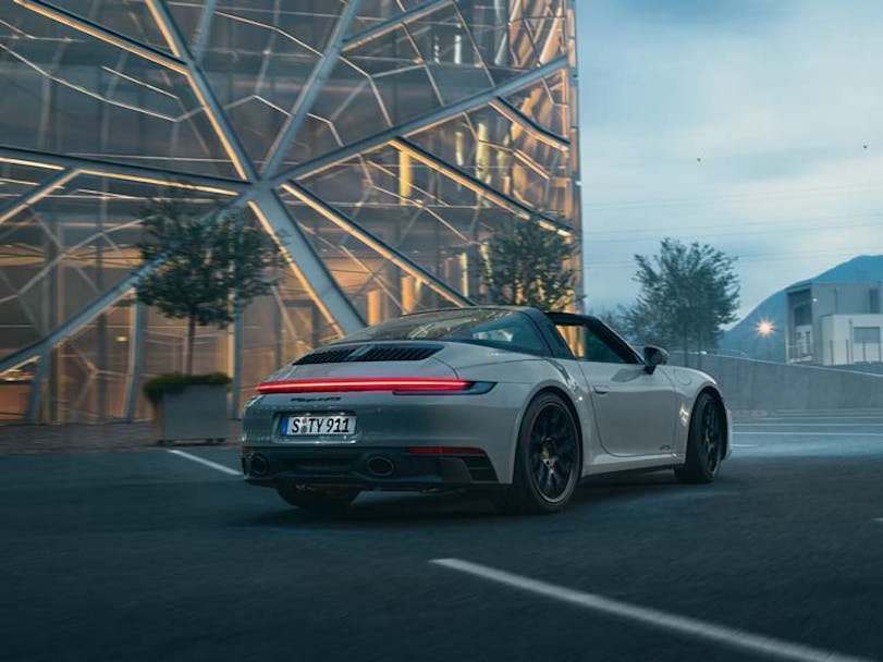 Rear view of Porsche 911 Targa (type 992.2) with glass building in background