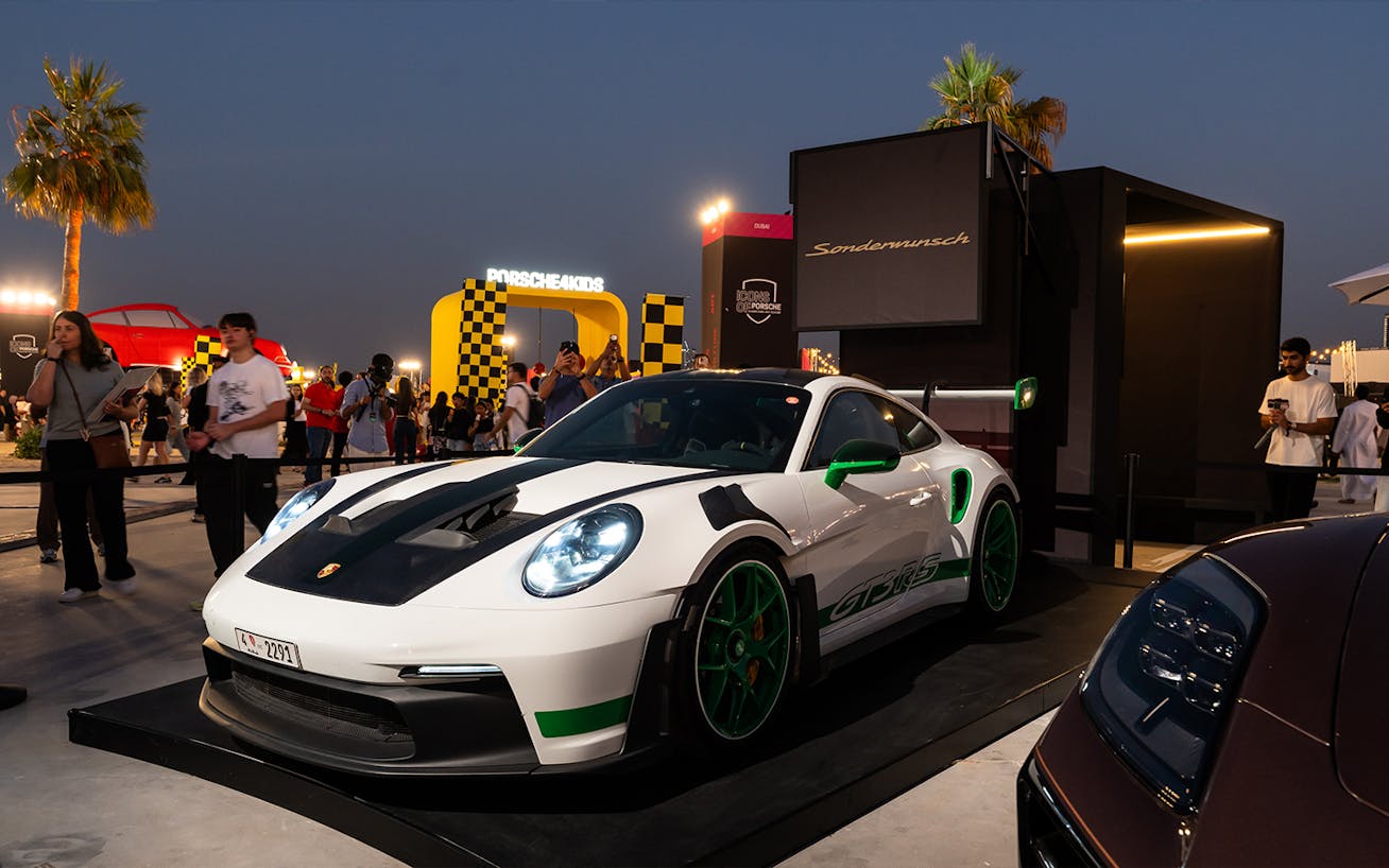 White Porsche 911 GT3 RS with green stripes and carbon fibre accents by Sonderwunsch at the 2025 Icons of Porsche, Dubai 