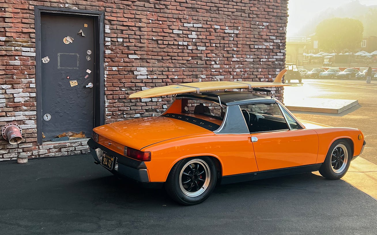 Porsche 914 in Signal Orange, brick building behind