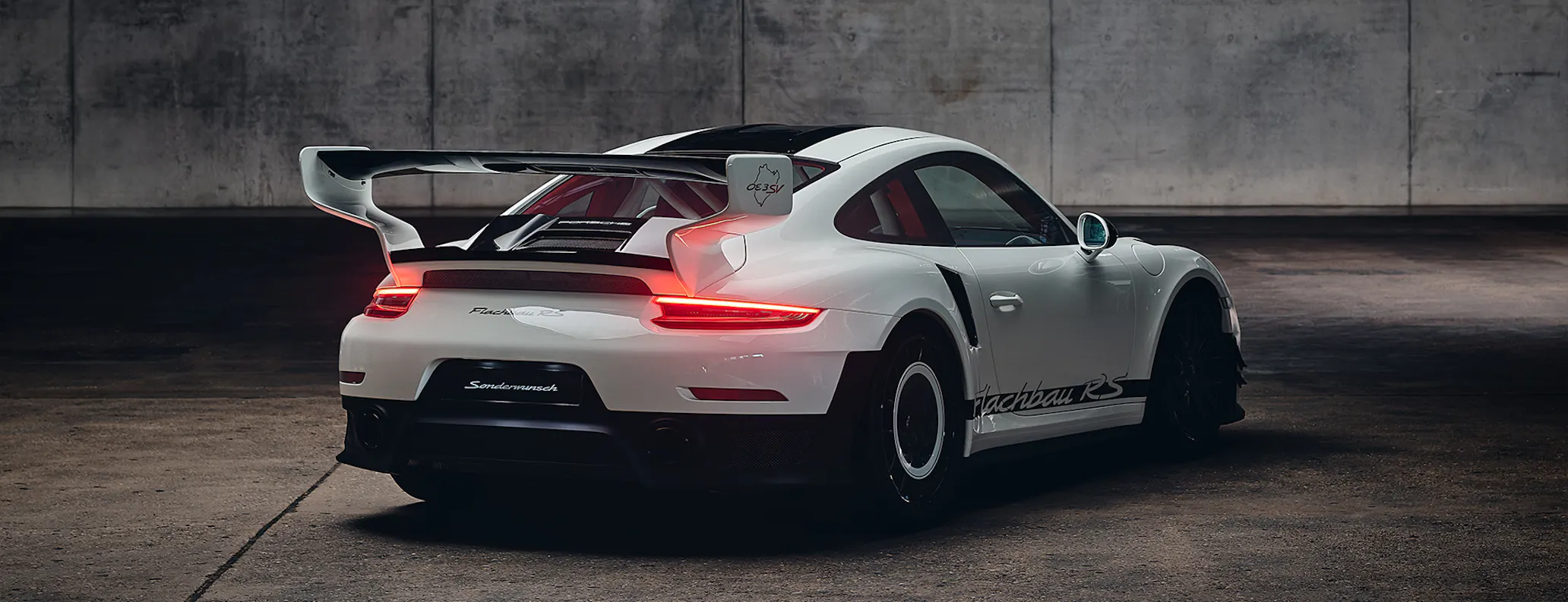 Porsche 911 Flachbau RS rear view in dark studio hero desktop