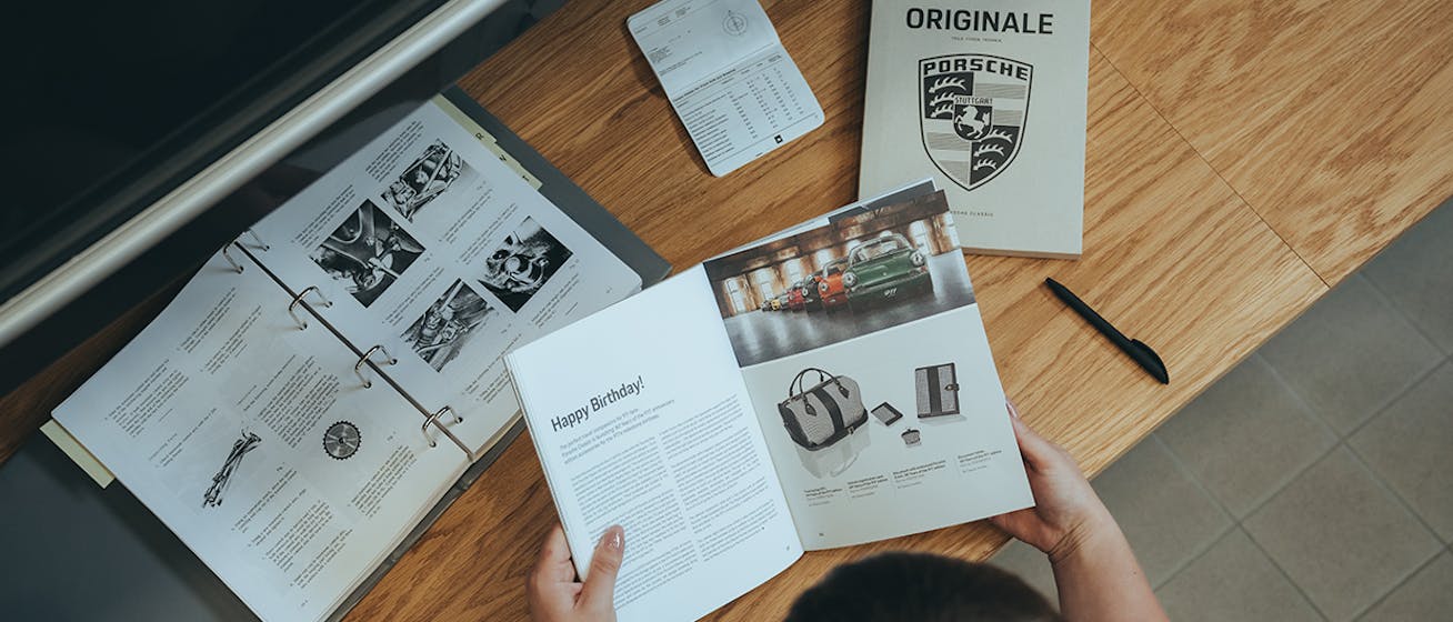 Bird’s-eye view of woman looking at Porsche ORIGINALE magazine