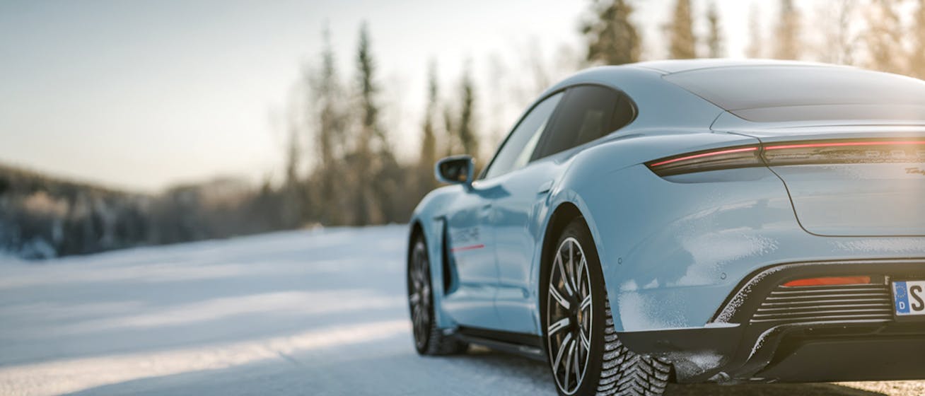 Rear view of Porsche Taycan GTS in snowy winter landscape