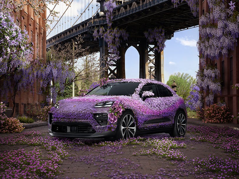 Porsche Macan covered in purple wisteria flowers, Brooklyn Bridge behind