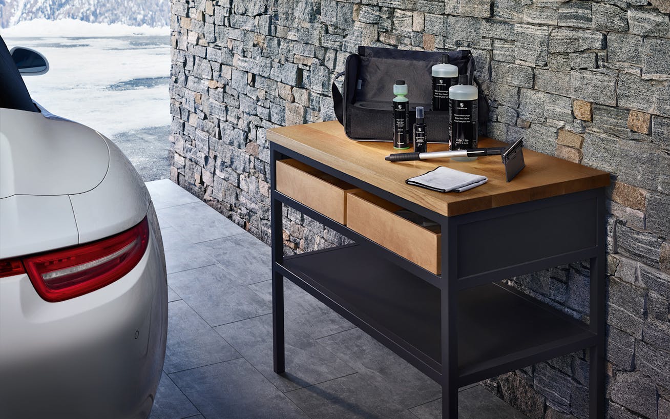 Close-up of garage interior, parked Porsche, table with car supplies