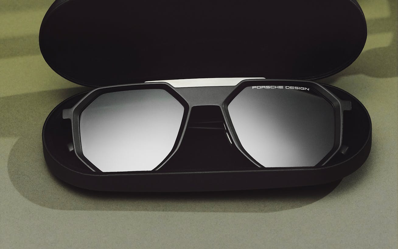 Black Porsche Design sunglasses displayed in an open case 