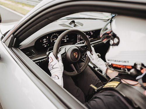 A racing driver sitting in a Porsche