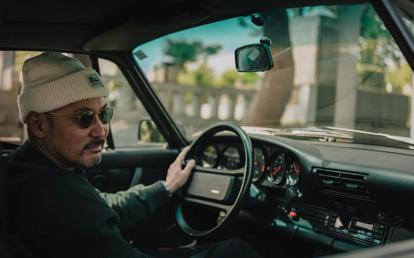 Close up of man behind the wheel of a Porsche 911 Carrera S/C