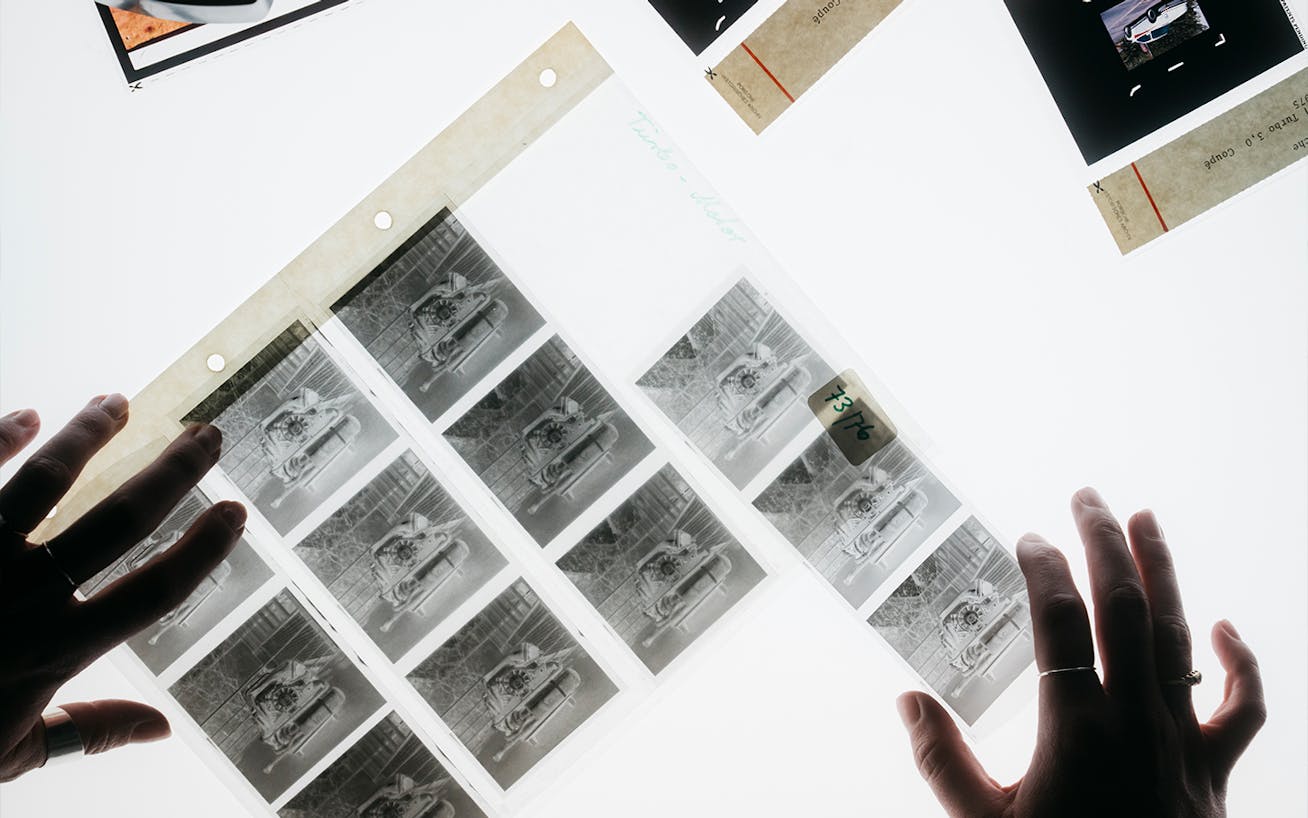 Close-up of hands moving around film negatives on table 