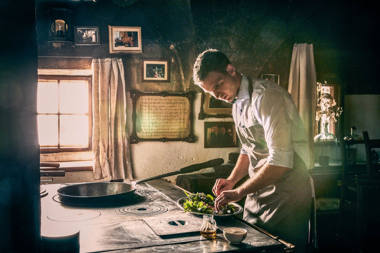 Young chef cooking over antique stove