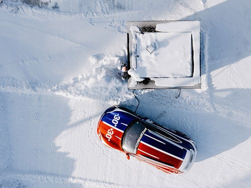 Aerial view of a Porsche Taycan Cross Turismo charging in snowy Finland