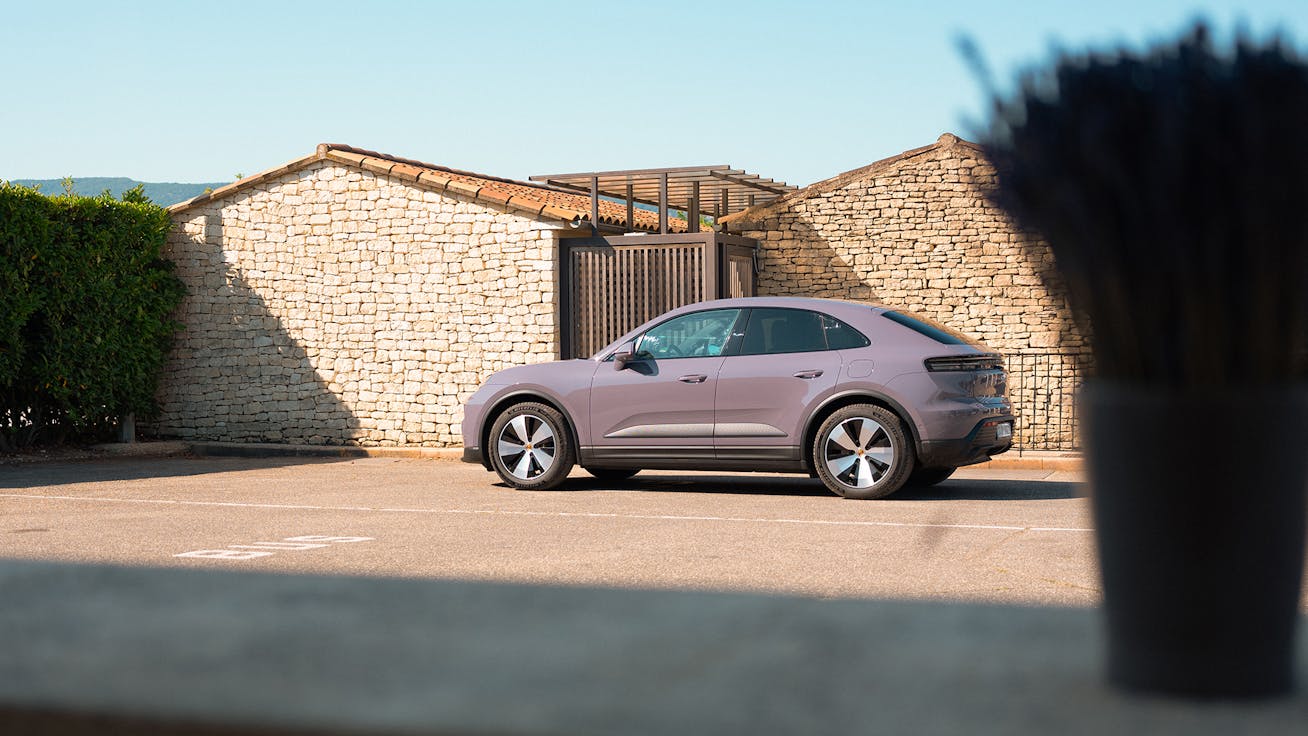 Porsche Macan 4 Electric parked near Provençal farm buildings