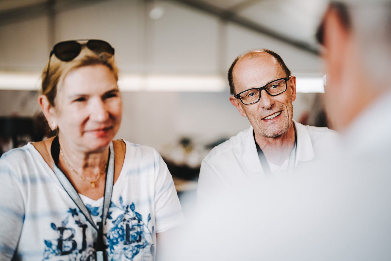 Man and woman in conversation at the Porsche Track Experience Master Training at the Nürburgring