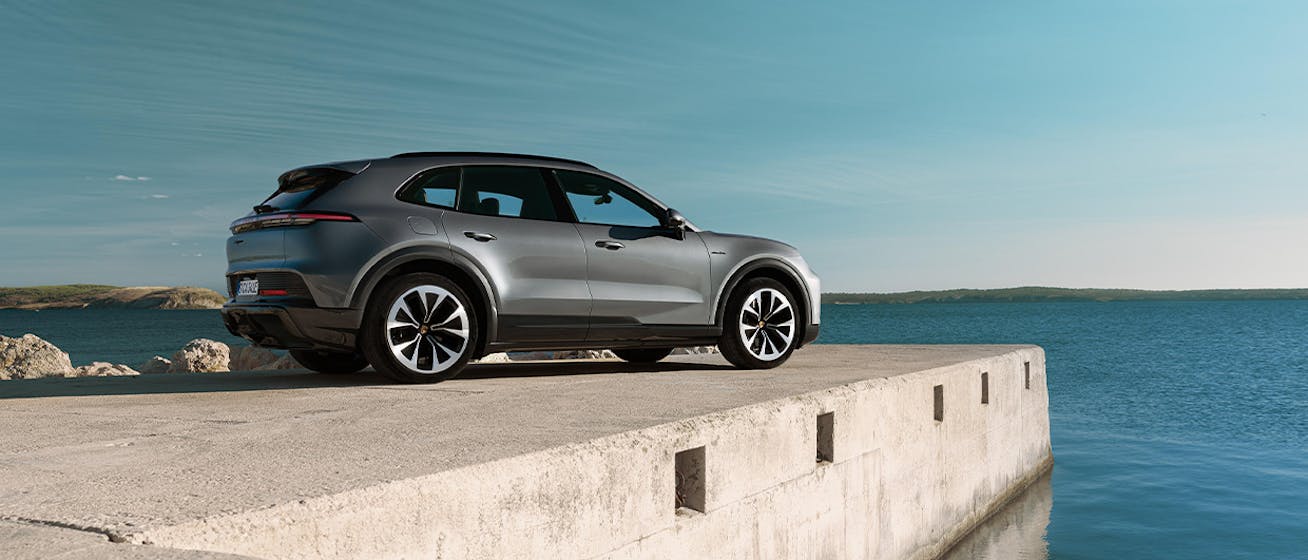 Porsche Cayenne Electric parked on concrete jetty overlooking ocean