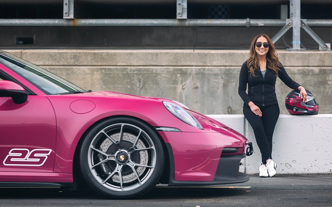 Woman leaning on pit wall by Porsche 911 GT3