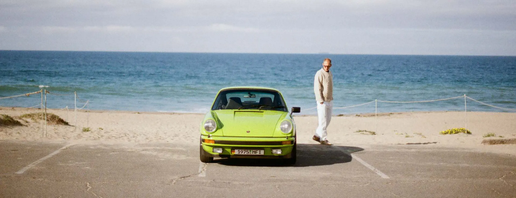 Birch Green Porsche 911 Carrera beside beach hero desktop
