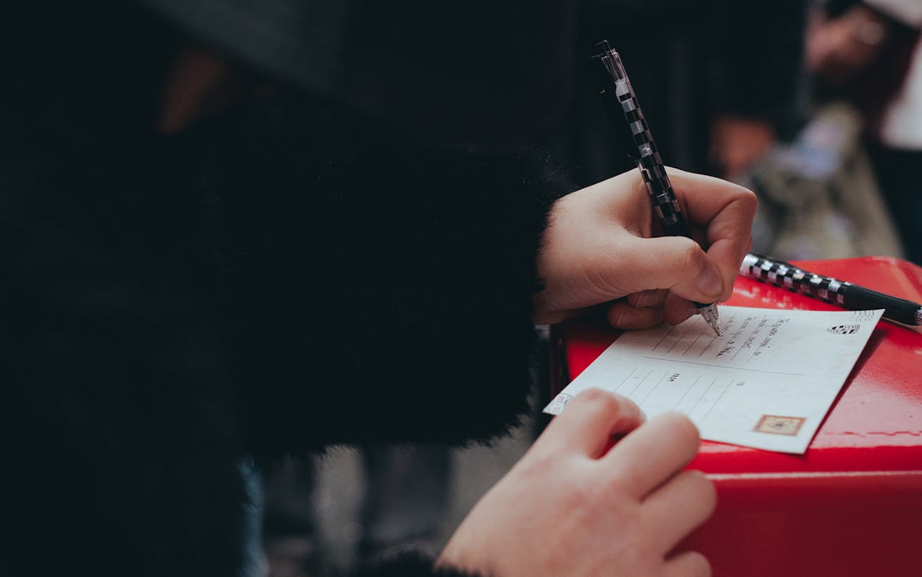 Person writes message on Greg Goya postcard as part of Porsche Valentines Day performance in Verona, Italy