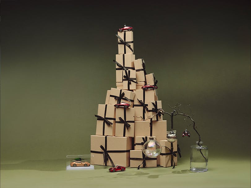 Holiday gift boxes decorated with miniature Porsche cars and ornaments 