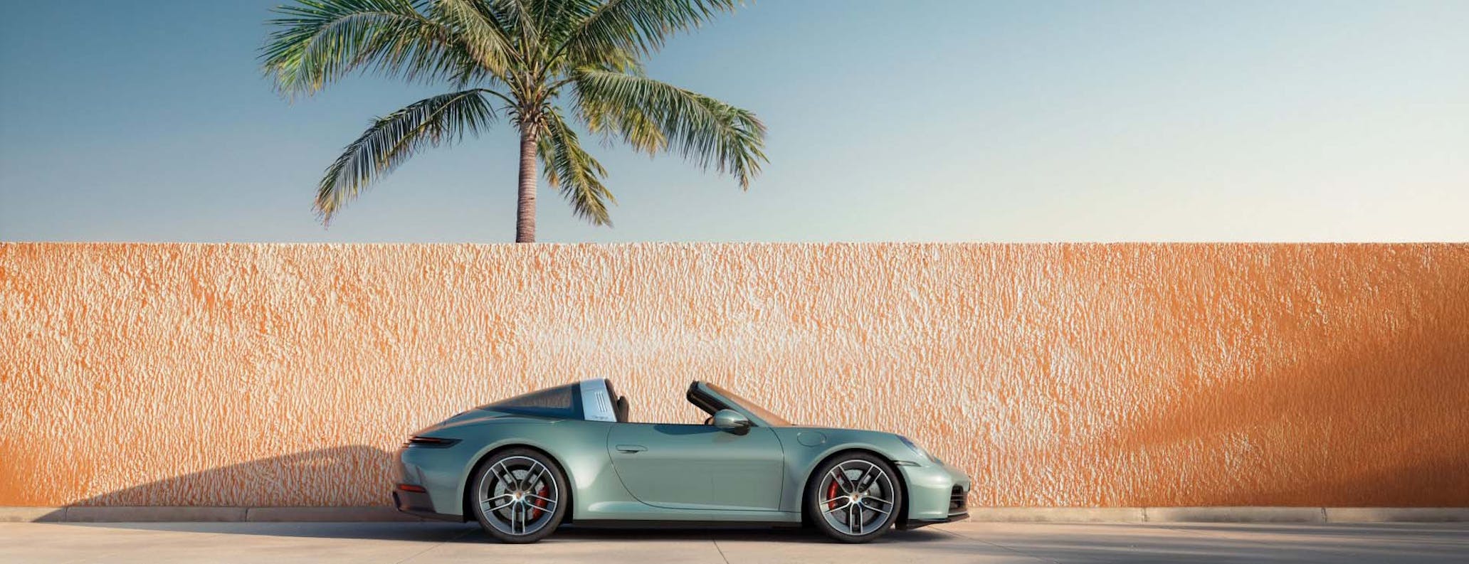 Porsche 911 Targa (type 992.2) pictured against a wall with palm tree in background
