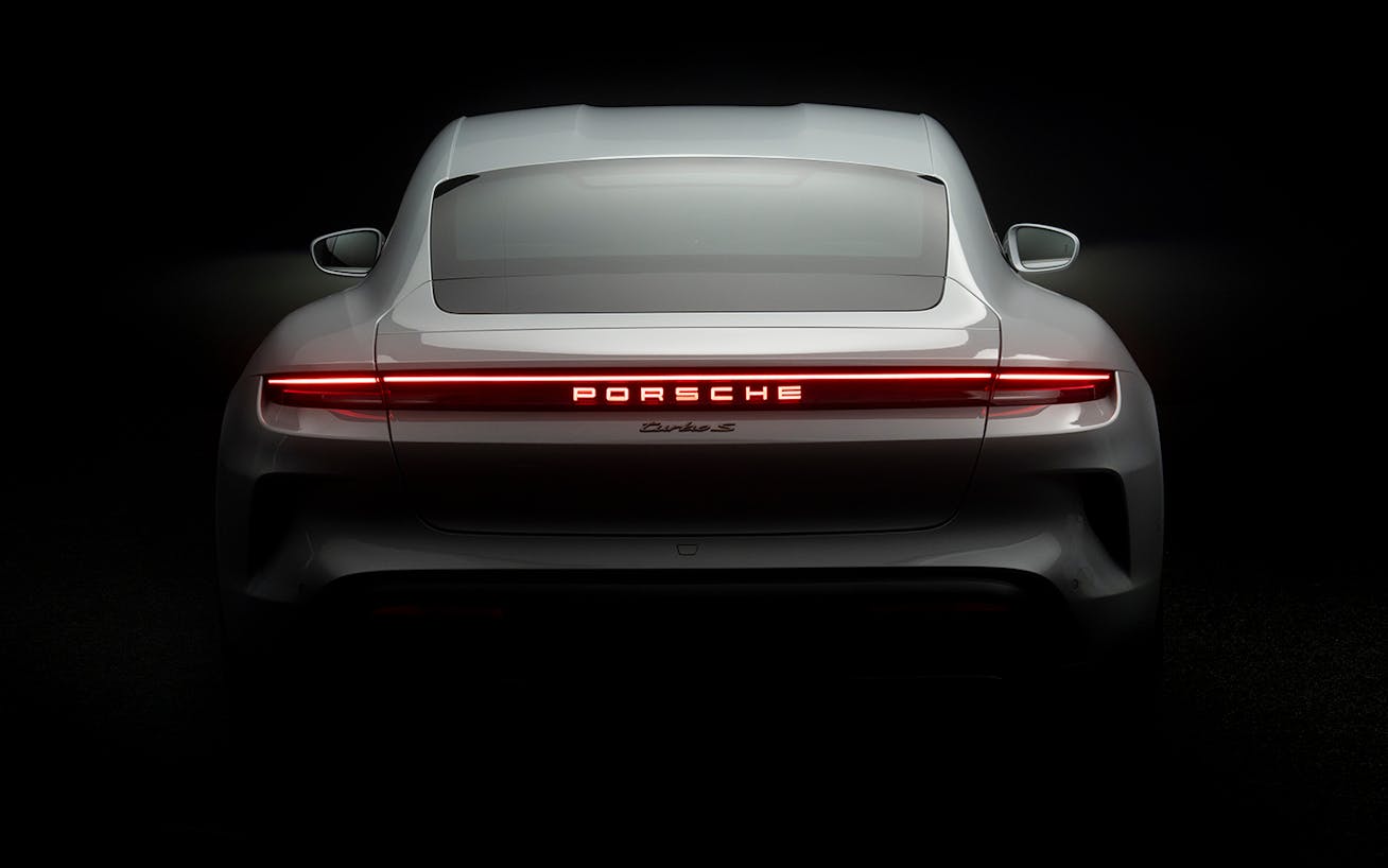 Rear view of new Porsche Taycan Turbo S with rear lights on 