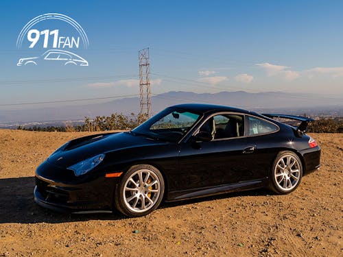 Black 911 (996) GT3 on gravel, mountains behind