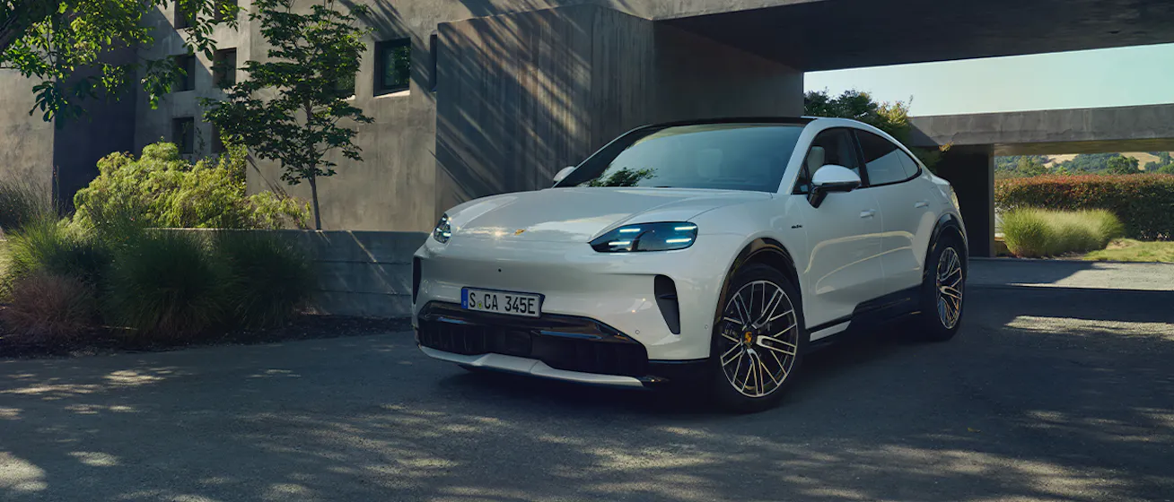 Porsche Cayenne S Coupé Electric_parked outside concrete-clad modern home_conversion desktop