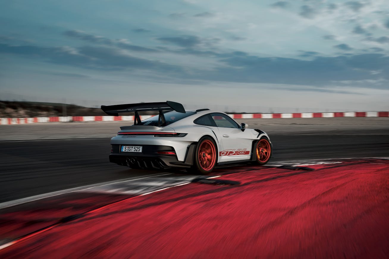Porsche 911 GT3 RS driving around corner on racetrack 