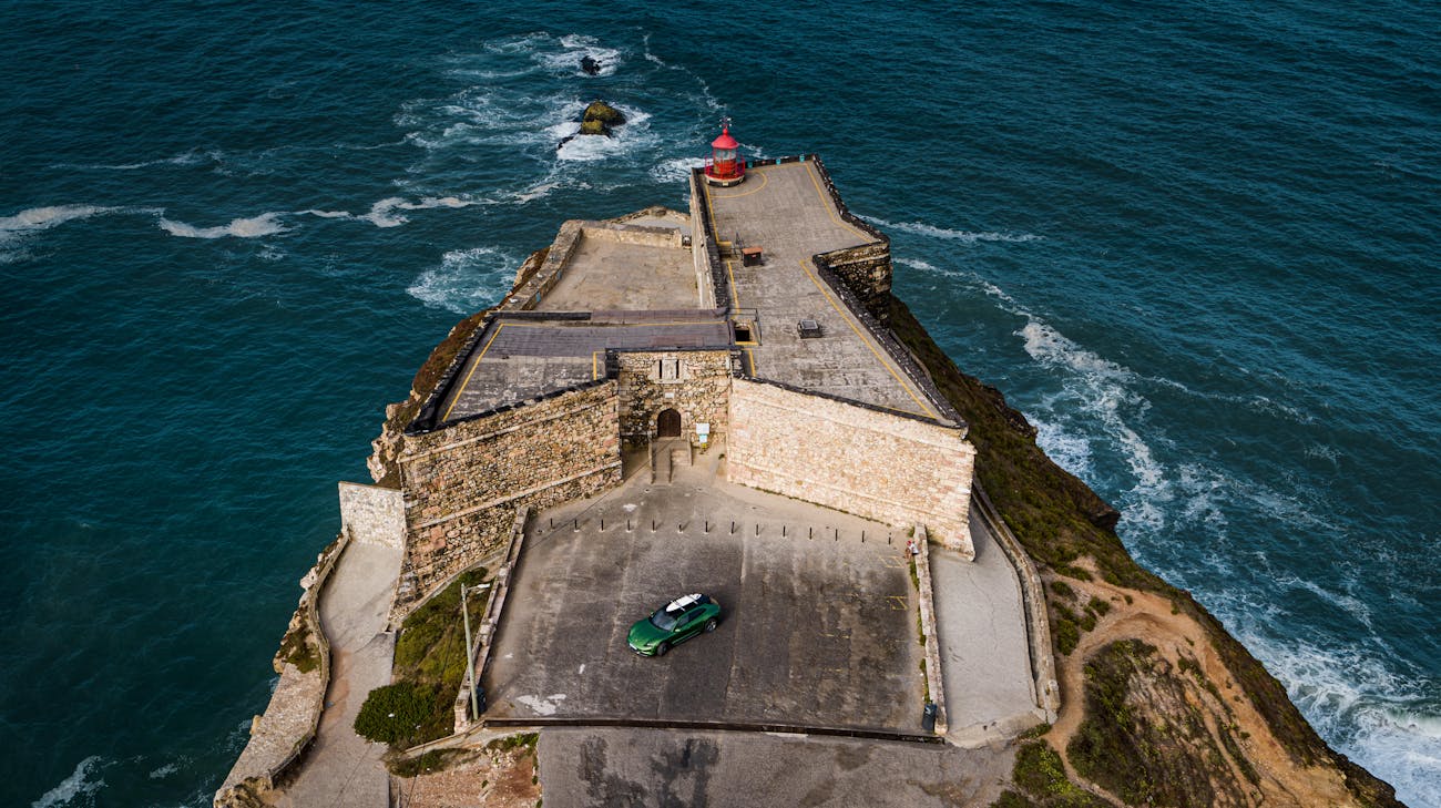 Aerial view of coastal fort with Porsche Taycan Cross Turismo