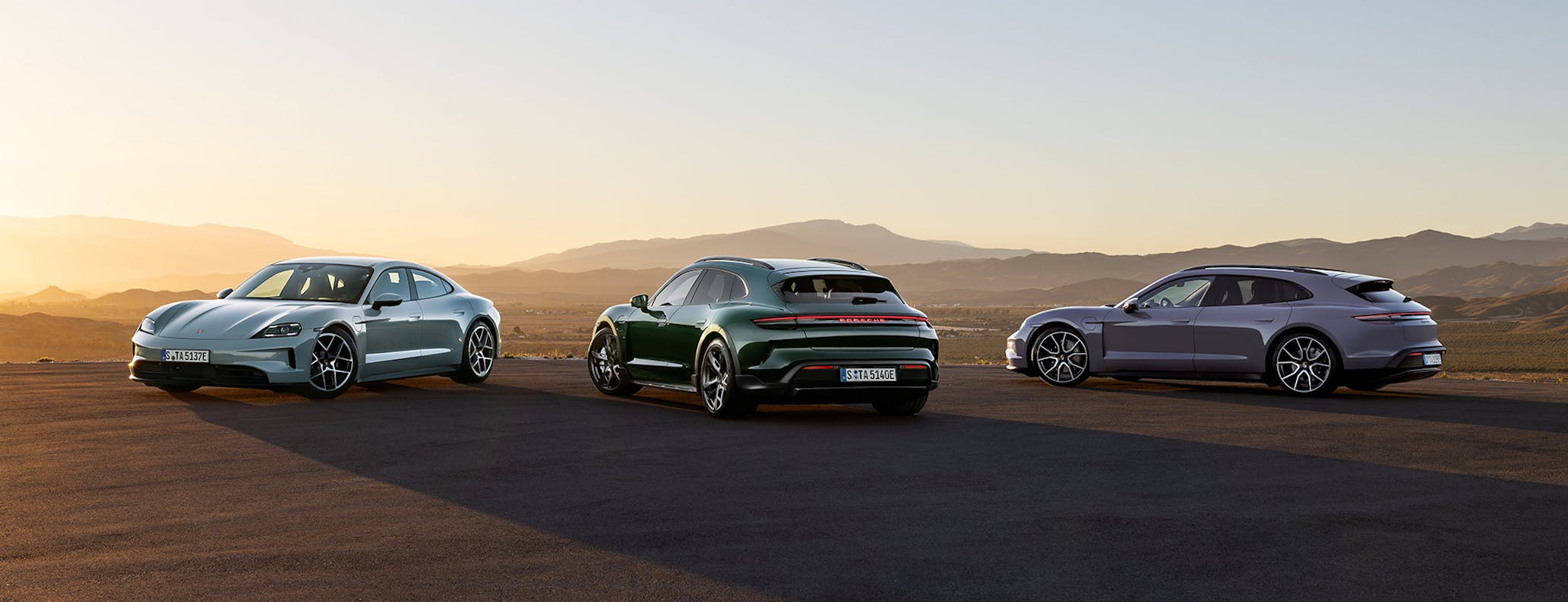 Porsche Taycan model range parked in desert setting at sunset