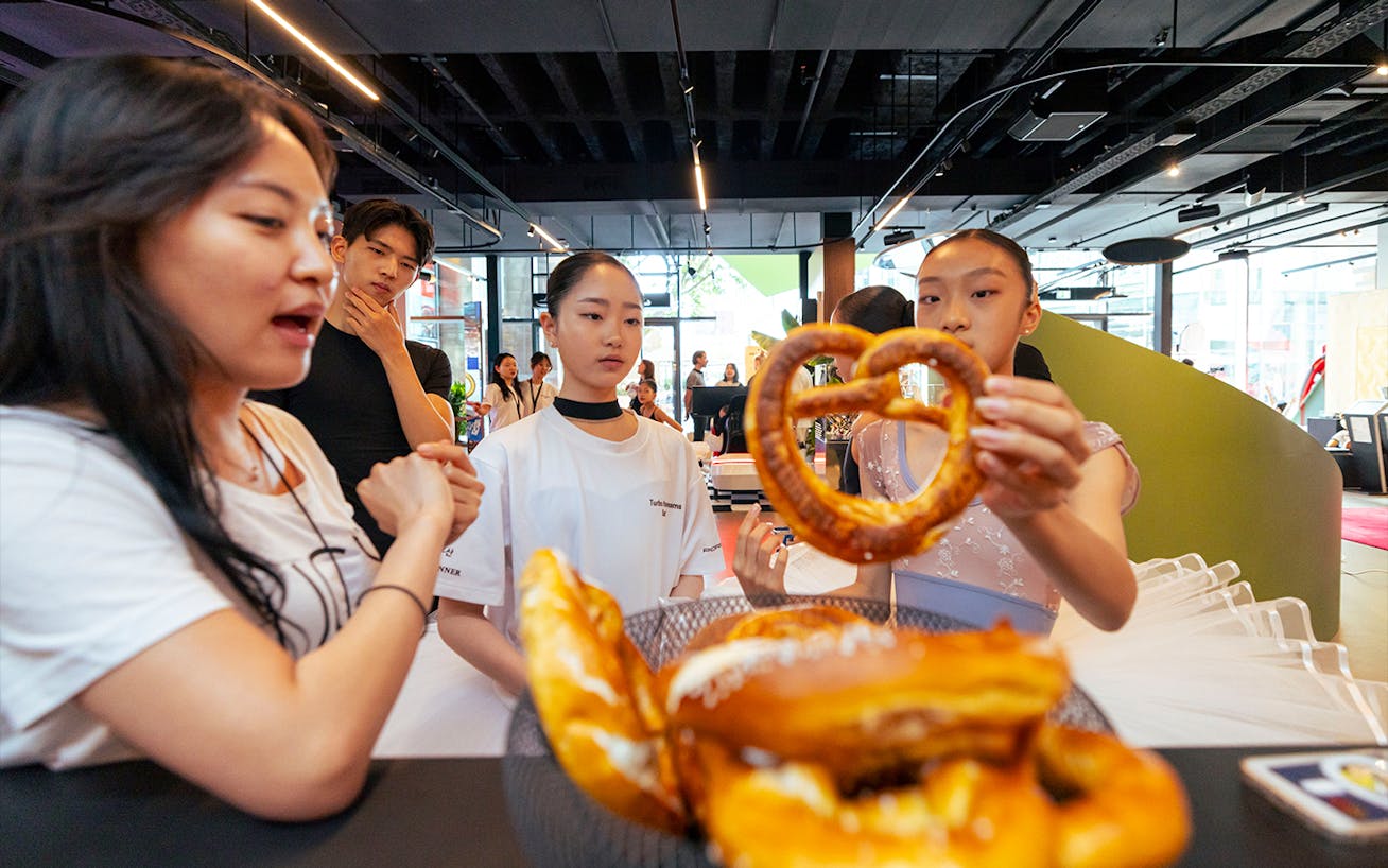 Ballet student picking up pretzel at Porsche Brand Store 