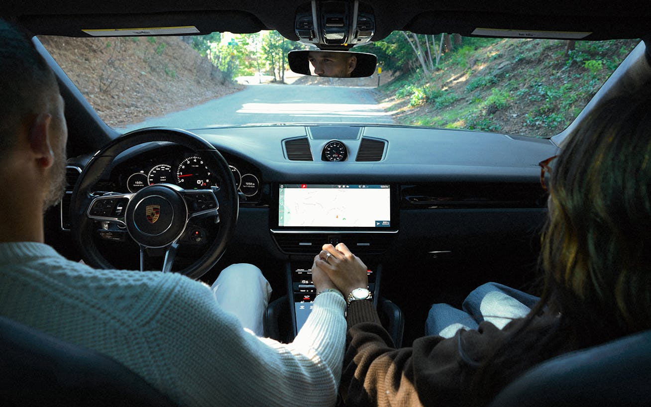 Julie Sariñana, aka Sincerely Jules, with husband in Porsche Cayenne coupé (E3) driving on hillside road in LA