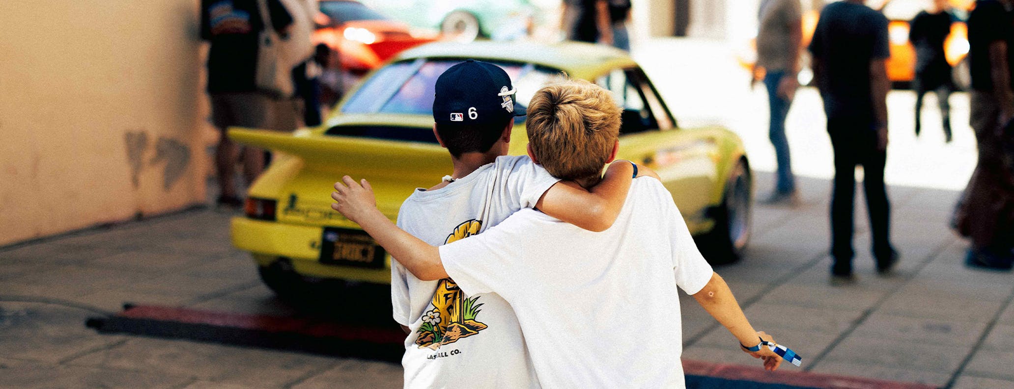 Two boys hug, looking at Porsche 911 Carrera RS 2.7