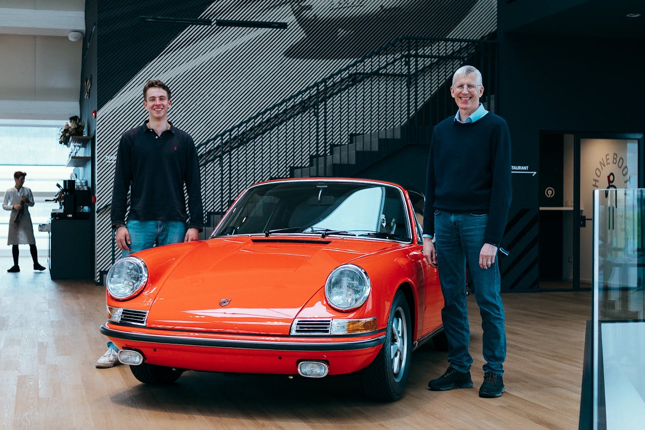 Two men with classic original Porsche 911 in Bahia Red