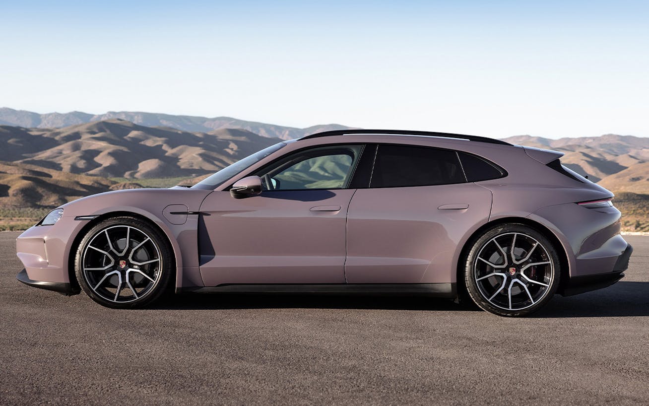 Porsche Taycan 4S Sport Turismo parked on road, mountains behind
