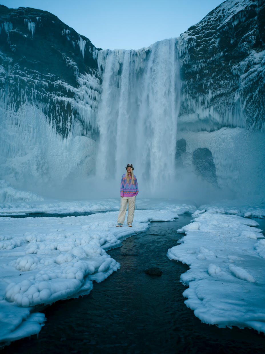 Woman standing in front of Skógafoss waterfall in Iceland