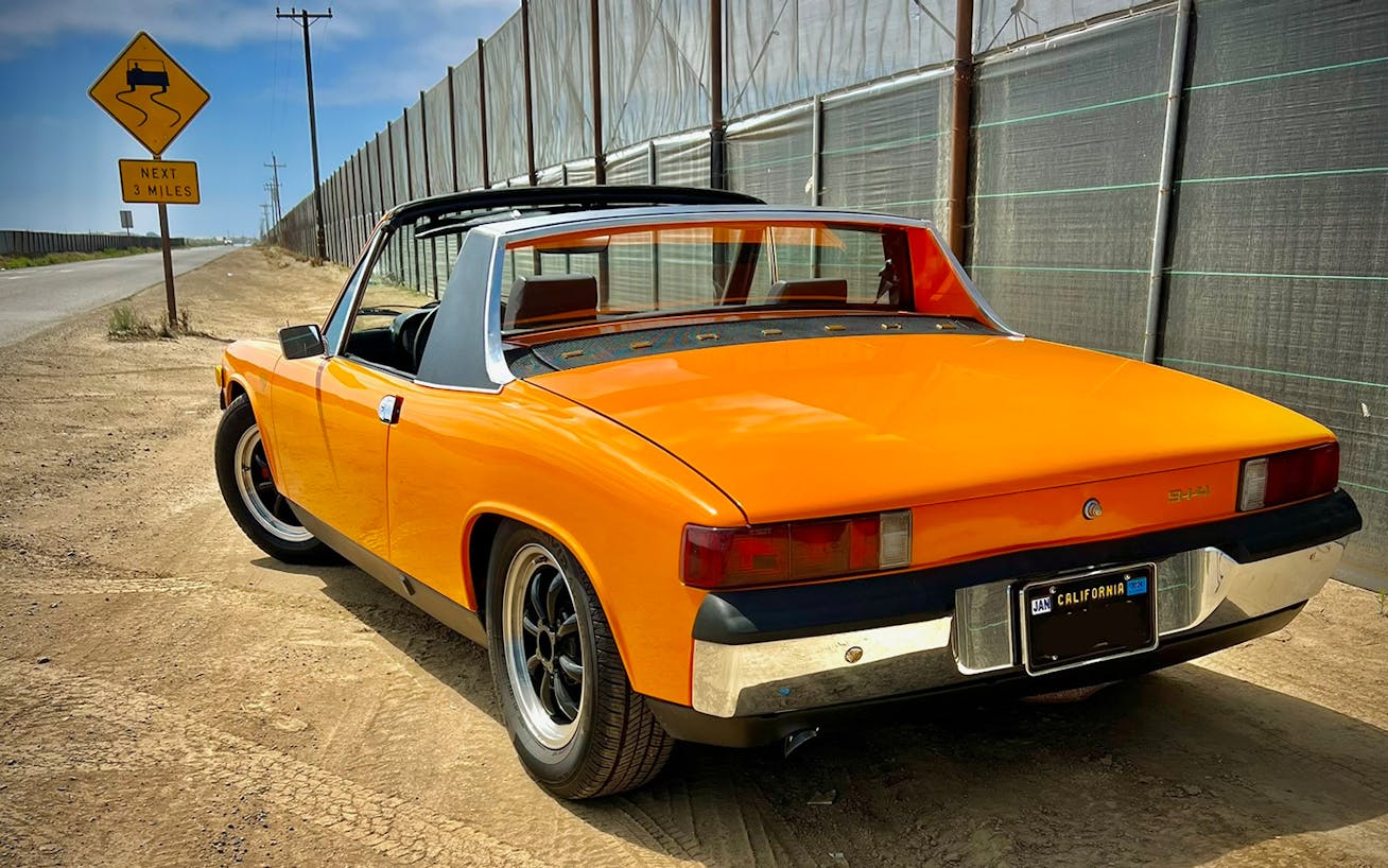 Porsche 914 in Signal Orange on beach at sunset