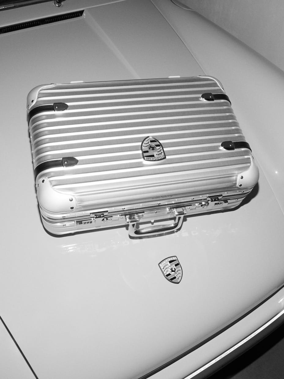 RIMOWA x Porsche Hand-Carry Case Pepita on hood of 911