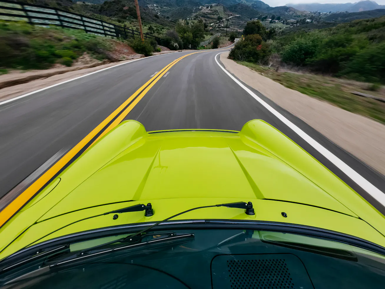 Image 2 bonnet view Birch Green 911 Carrera driving along mountain road
