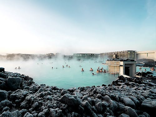 People bathing in a blue lagoon in Iceland