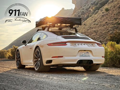 Porsche 911 Carrera 4 with roof tent attached at sunset