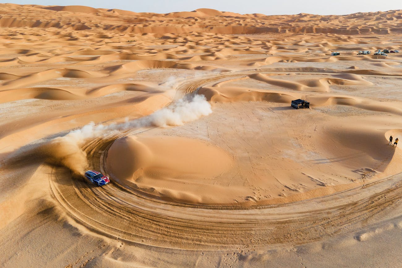 Porsche Taycan Cross Turismo drifts on a bend through desert