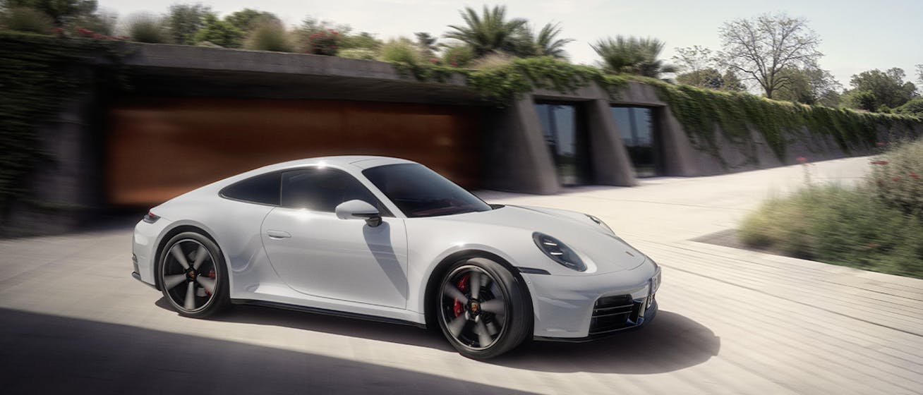 Sunlit Porsche 911 Carrera S in modern architectural setting