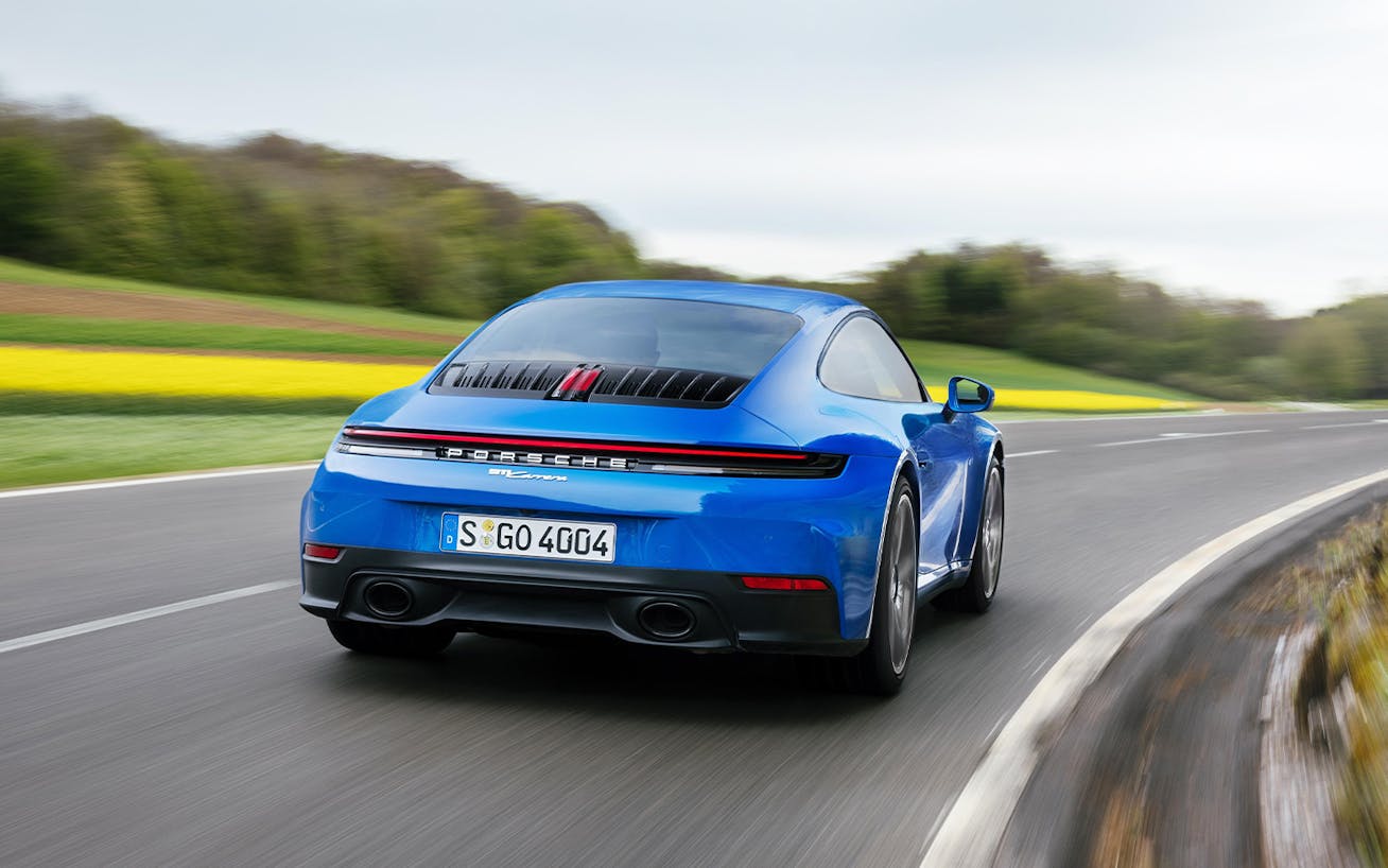 Porsche 911 Carrera in Lugano Blue drives through a bend