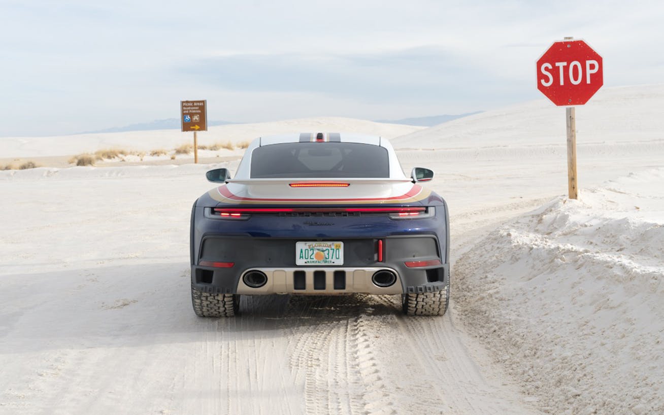 Porsche 911 Dakar driving through white desert sands