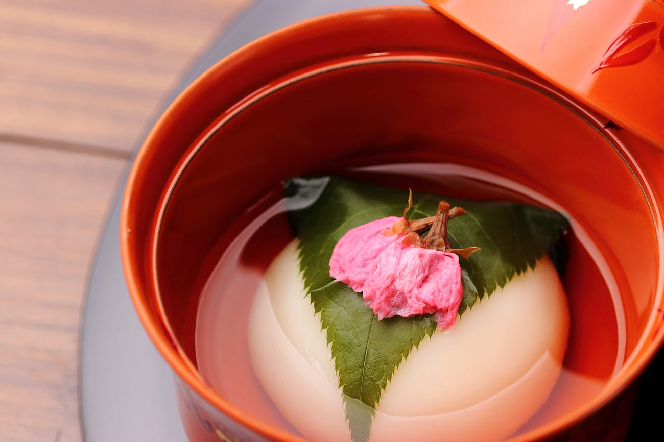 Japanese dish, artistically garnished, with cherry blossoms in a broth