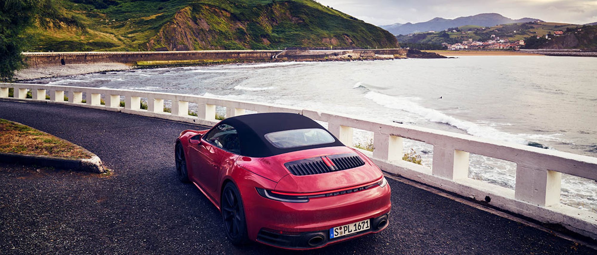 Red Porsche driving next to the lake