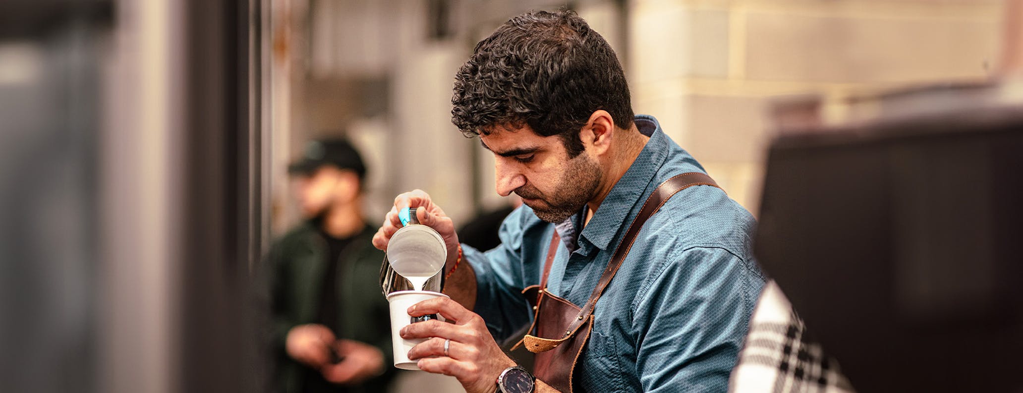 Barista pouring a cup of coffee in coffee shop