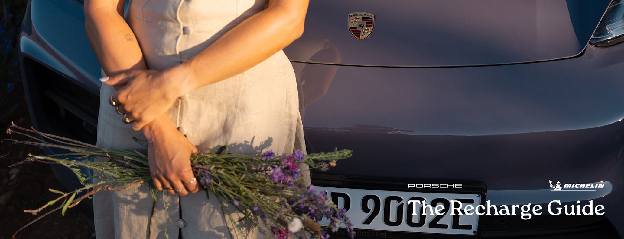 Close-up of person holding lavender, Porsche Macan behind