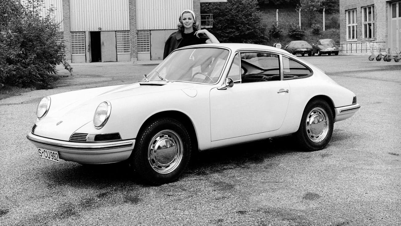 Woman standing behind first Porsche 911 prototype
