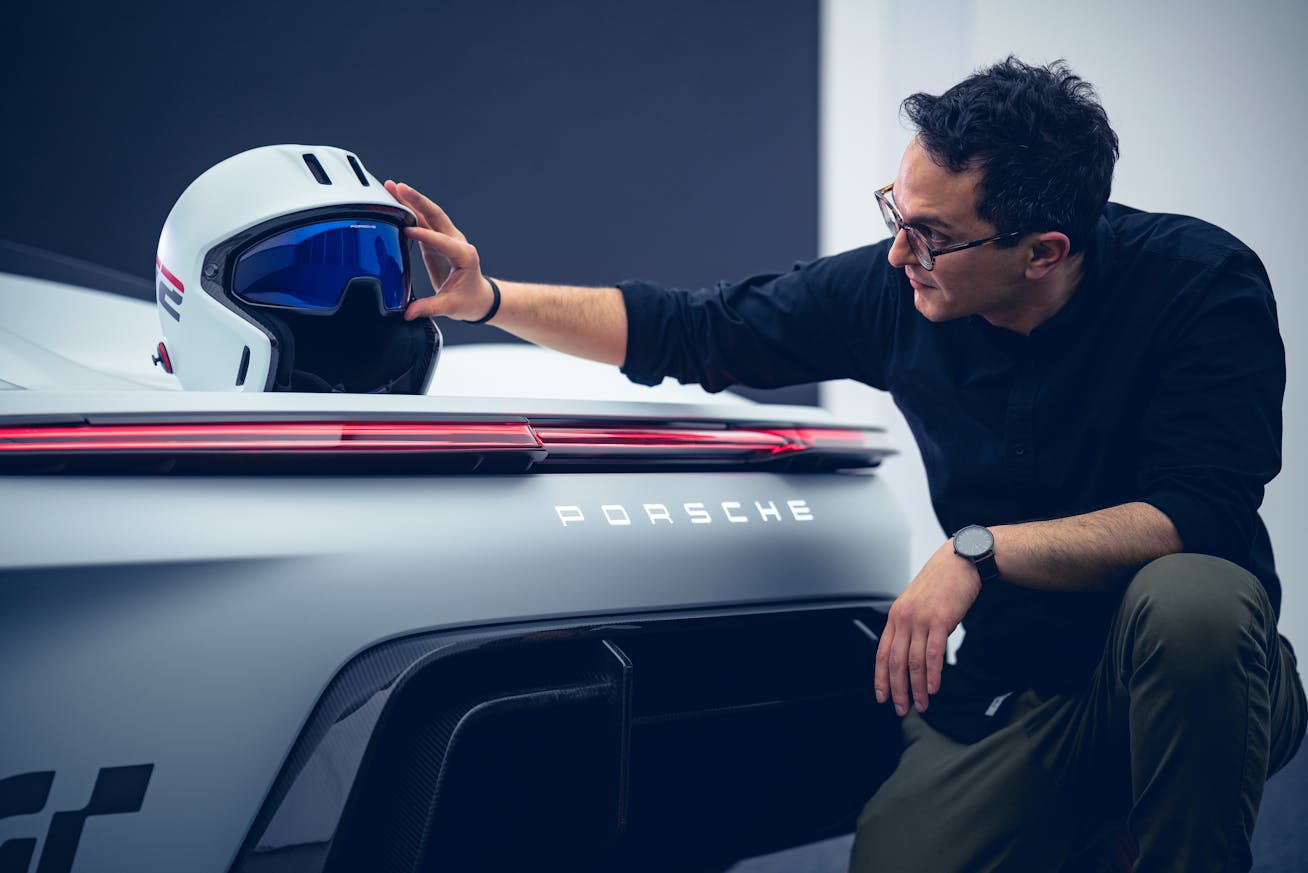 Driver helmet on Porsche Vision GT, man kneeling beside it