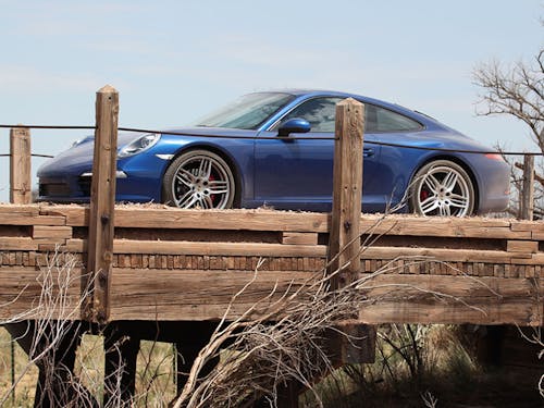 Blue Porsche 911 991 on a rickety wooden bridge
